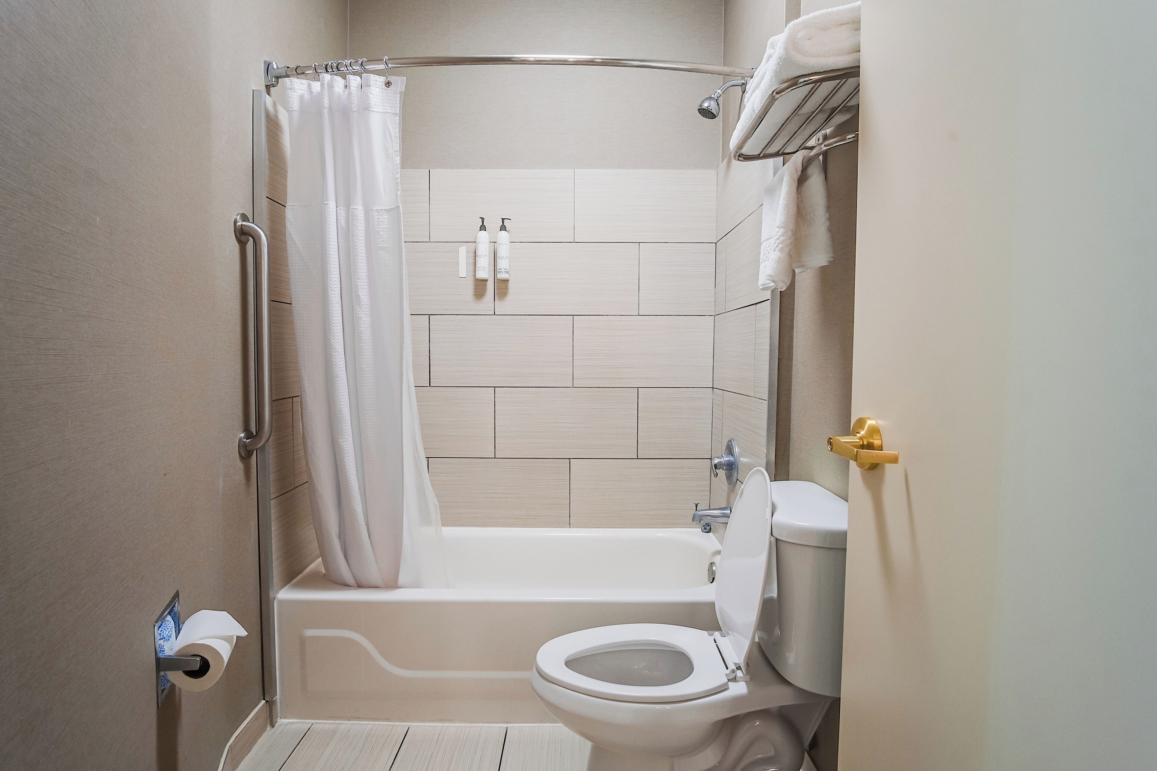 Un bagno moderno con vasca, WC e tenda da doccia.