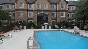 A hotel with a pool area, including lounge chairs and a no diving sign. - Sonesta ES Suites San Antonio Northwest - Medical Center (San Antonio)