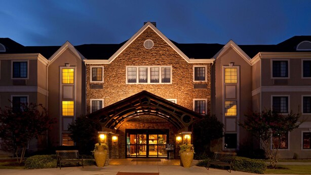 A multi-story building with a stone facade, large windows, and a prominent entrance with a covered porch. - Sonesta ES Suites San Antonio Northwest - Medical Center (San Antonio)