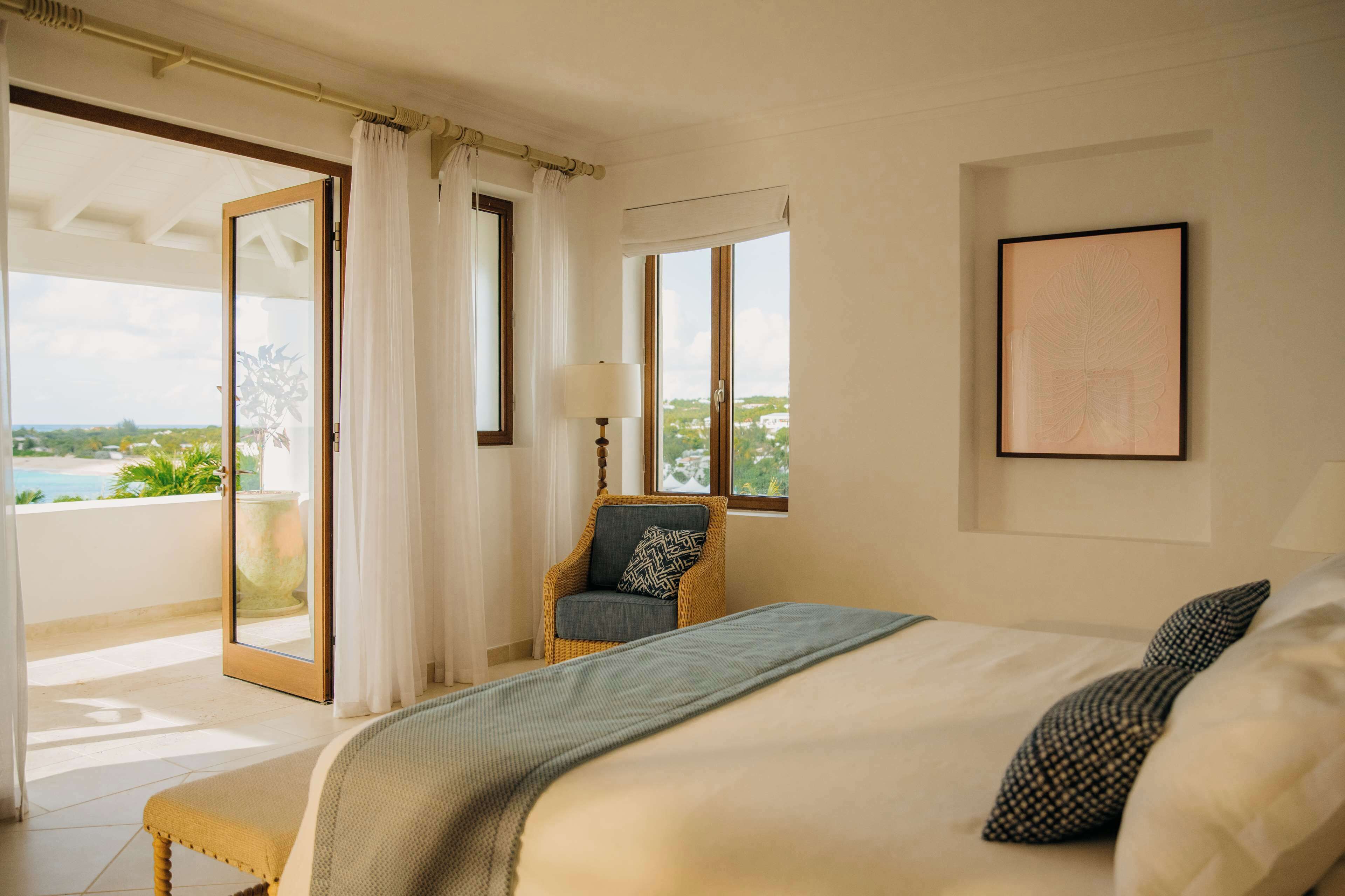 Une chambre à coucher avec un lit, une chaise, une fenêtre et une vue sur l’extérieur.