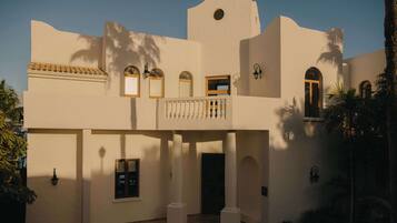 A building with multiple balconies, arched windows, and a central entrance.