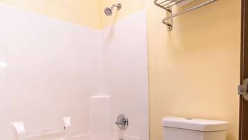 A bathroom with a bathtub, toilet, and a towel rack.