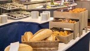 A buffet with various baked goods, including bread and pastries, arranged on a table. - The Imperial Hotel (Blackpool)