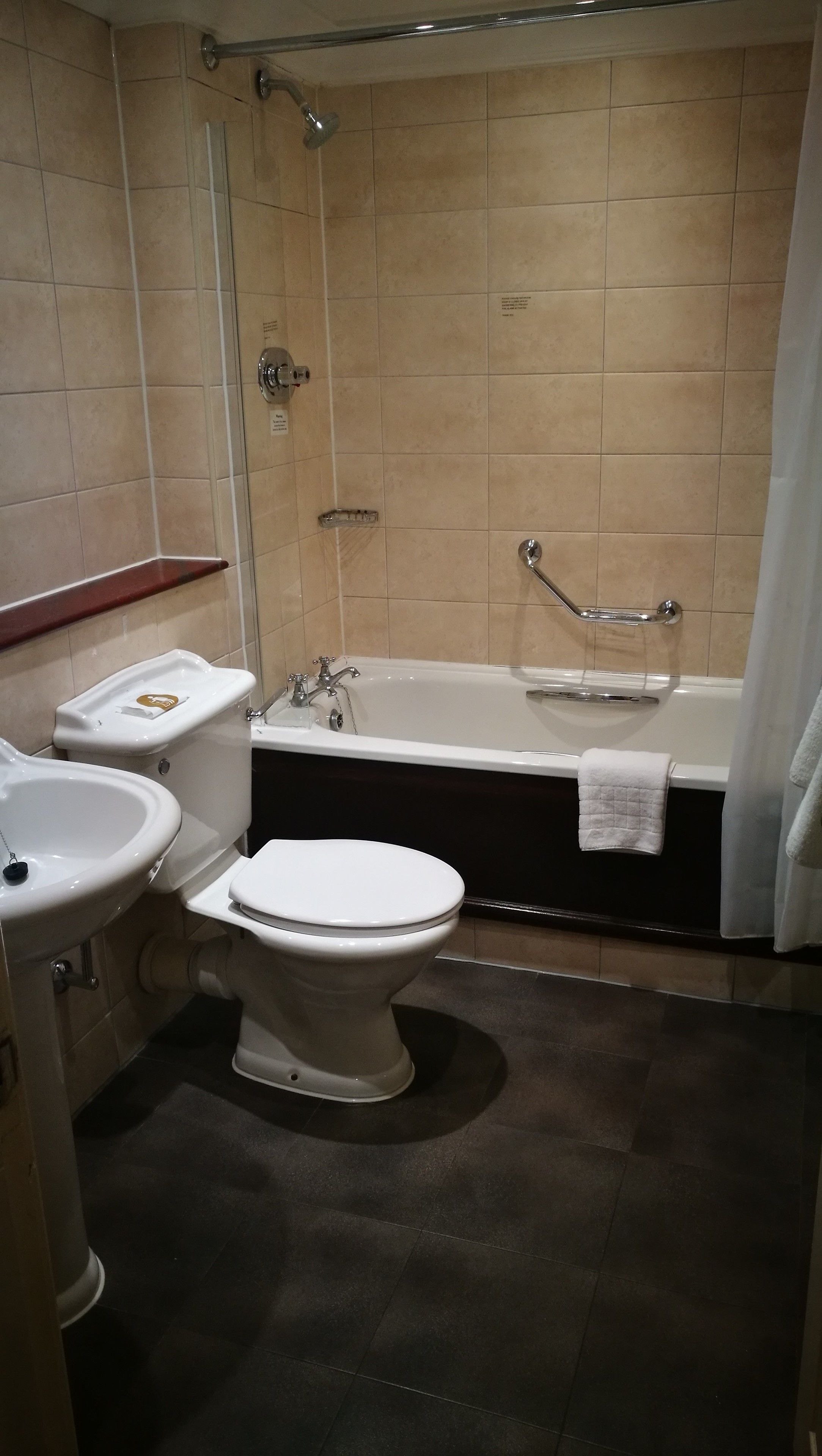 A bathroom with a toilet, sink, bathtub, and shower.