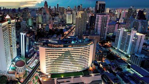 Un hotel moderno con fachada curva, varios pisos y un llamativo letrero 
