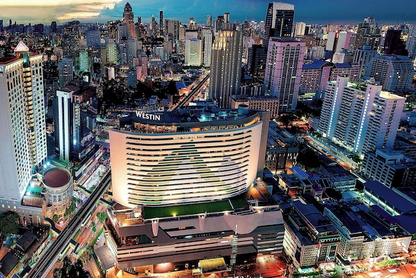 Un hotel moderno con fachada curva, varios pisos y un llamativo letrero 