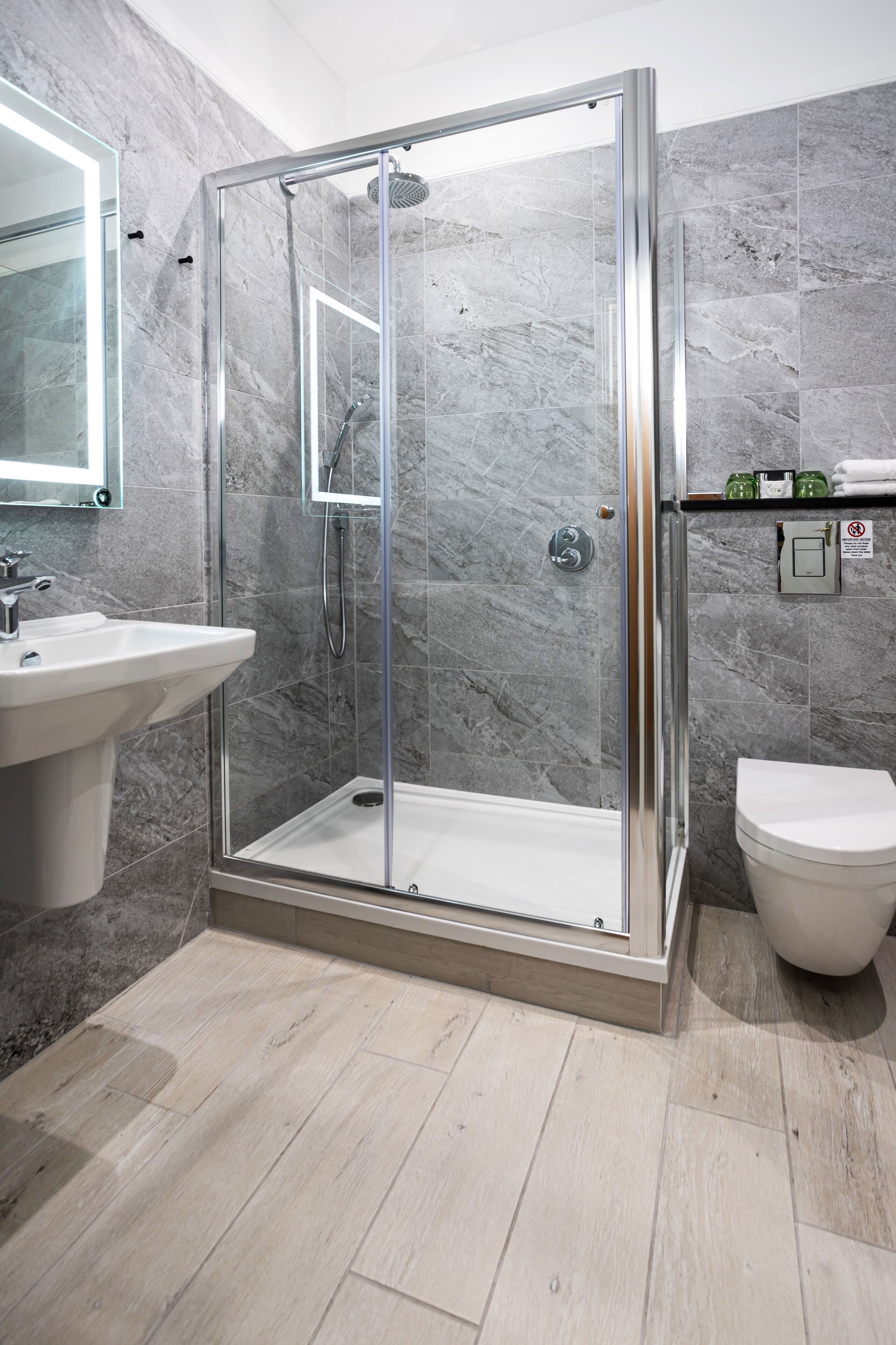 Un bagno moderno con doccia vetrata, lavandino e WC.