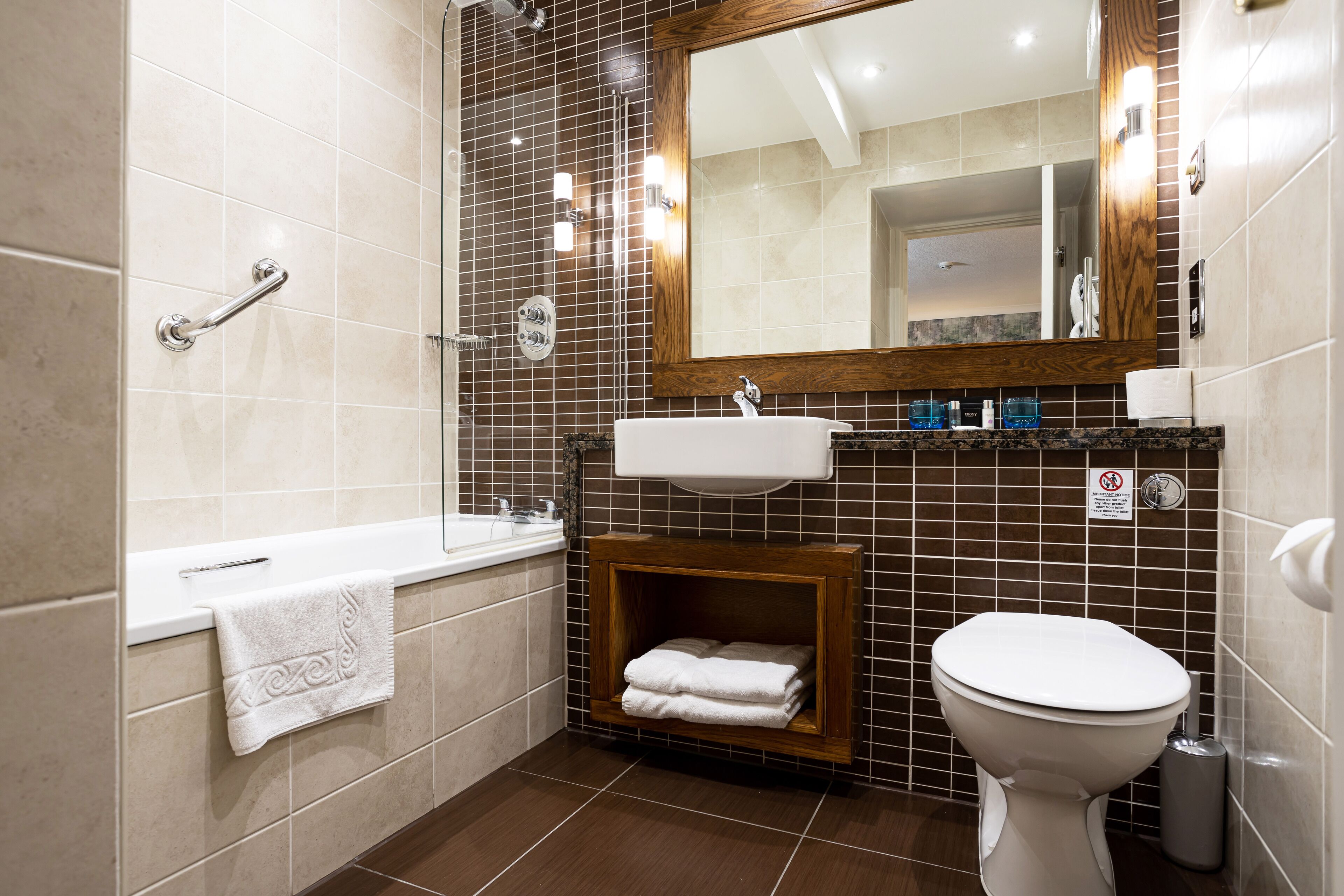 A modern bathroom with a bathtub, sink, and toilet.
