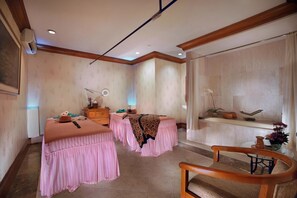 Una habitación con dos camas, una silla de madera, una mesita, un espejo y una ventana.