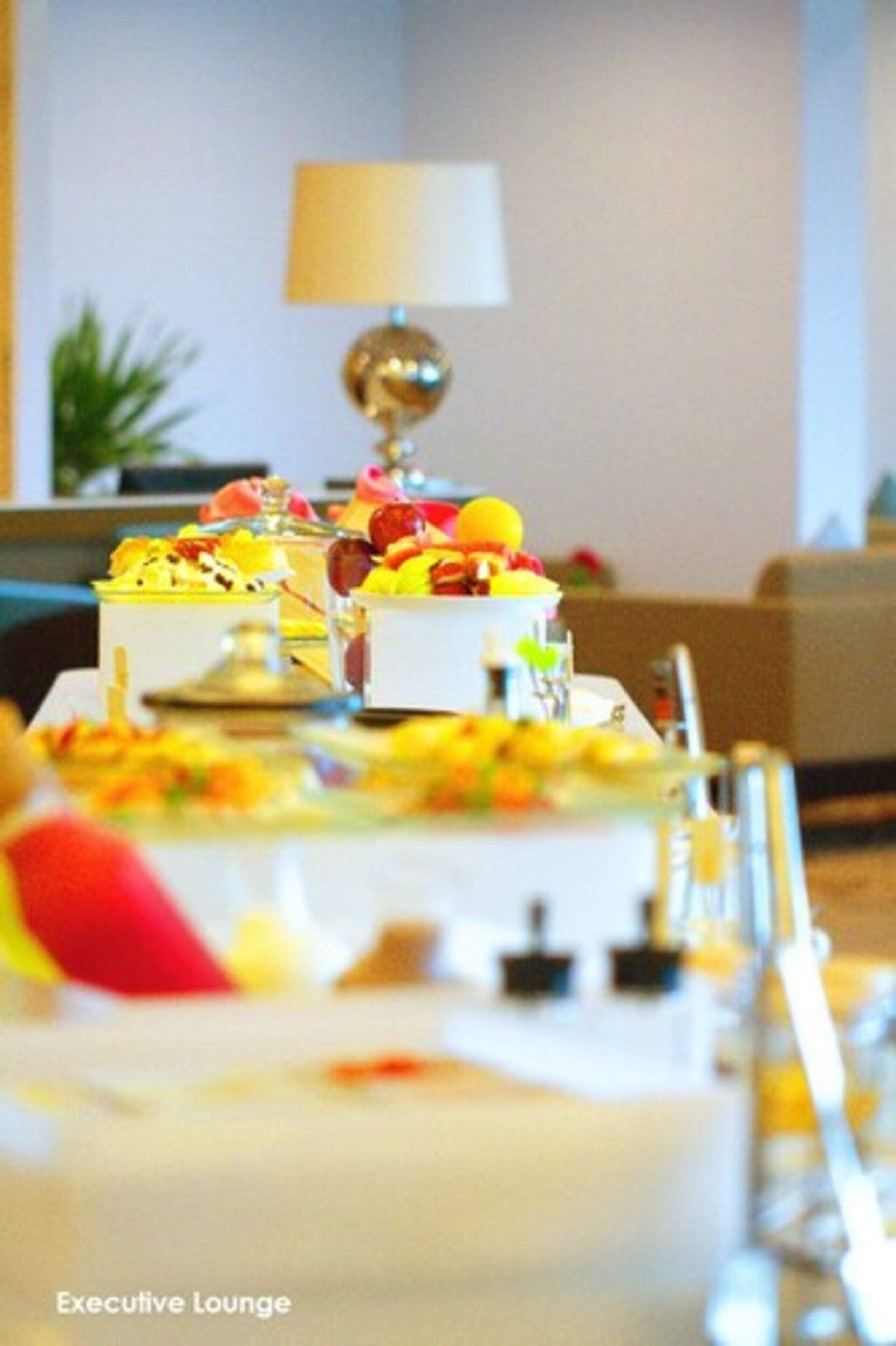 A dining table set with various dishes and a lamp in the background.