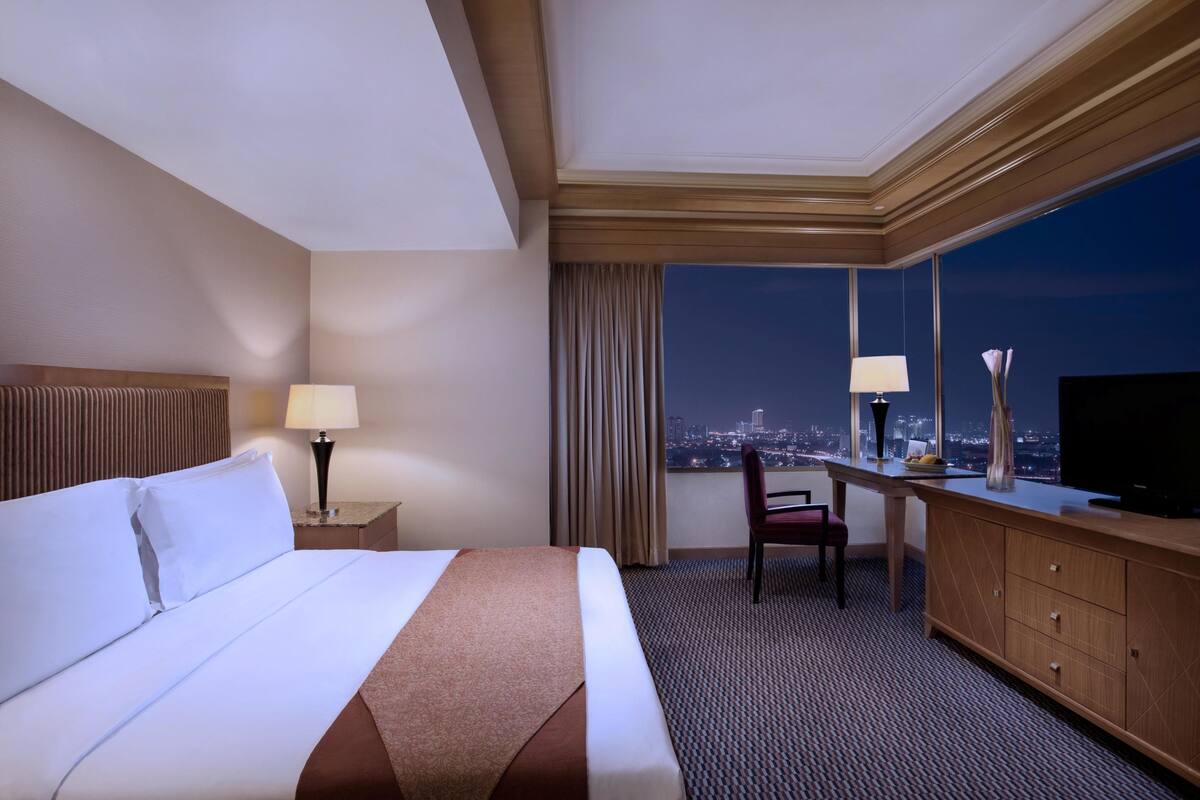 Deluxe kamer | Luxe beddengoed, een minibar, een kluis op de kamer, een bureau