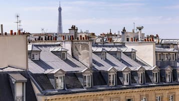 Une rangée de bâtiments aux toits à forte pente et aux lucarnes, caractéristiques de l’architecture parisienne.