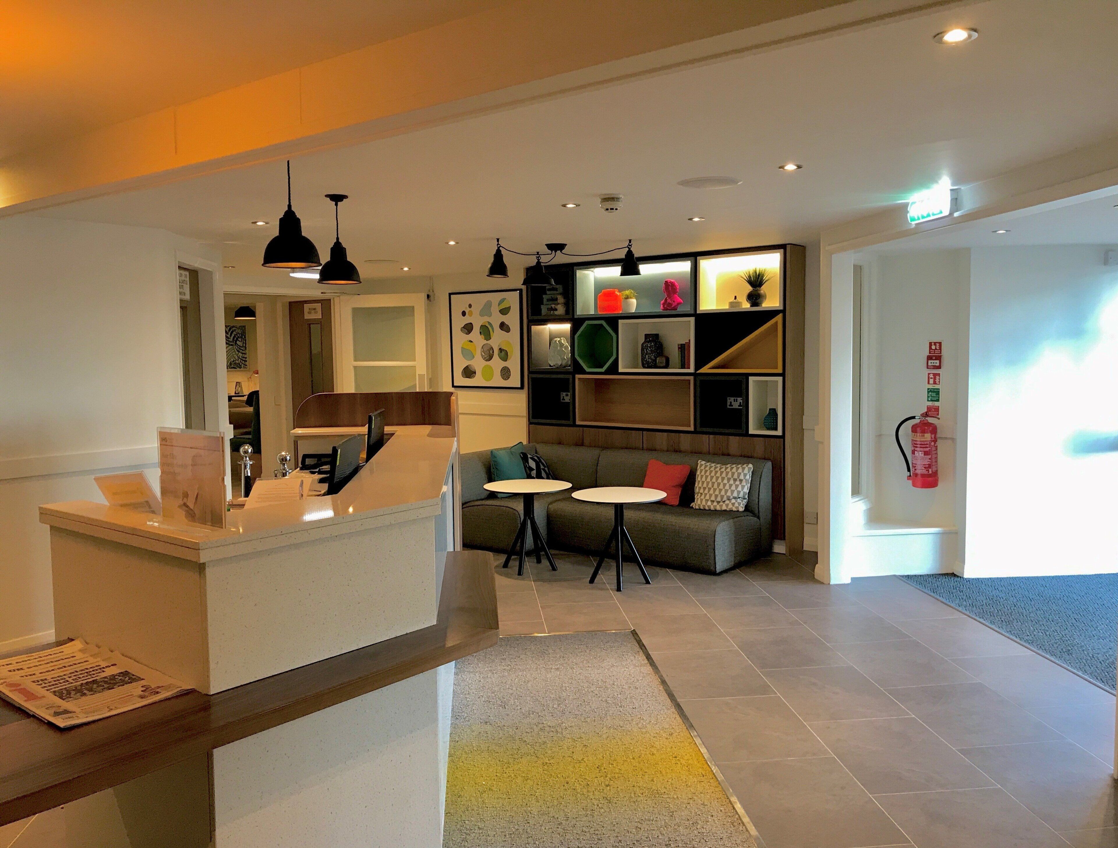 A modern interior with a reception desk, a sofa, and a small table.
