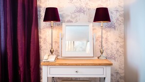 A vanity with a mirror, two lamps, and a telephone on a wooden counter. - Holiday Inn A55 Chester West by IHG (Deeside)