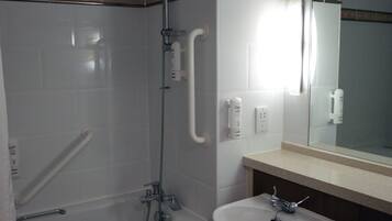 Ein Badezimmer mit Dusche, Waschbecken und Spiegel.