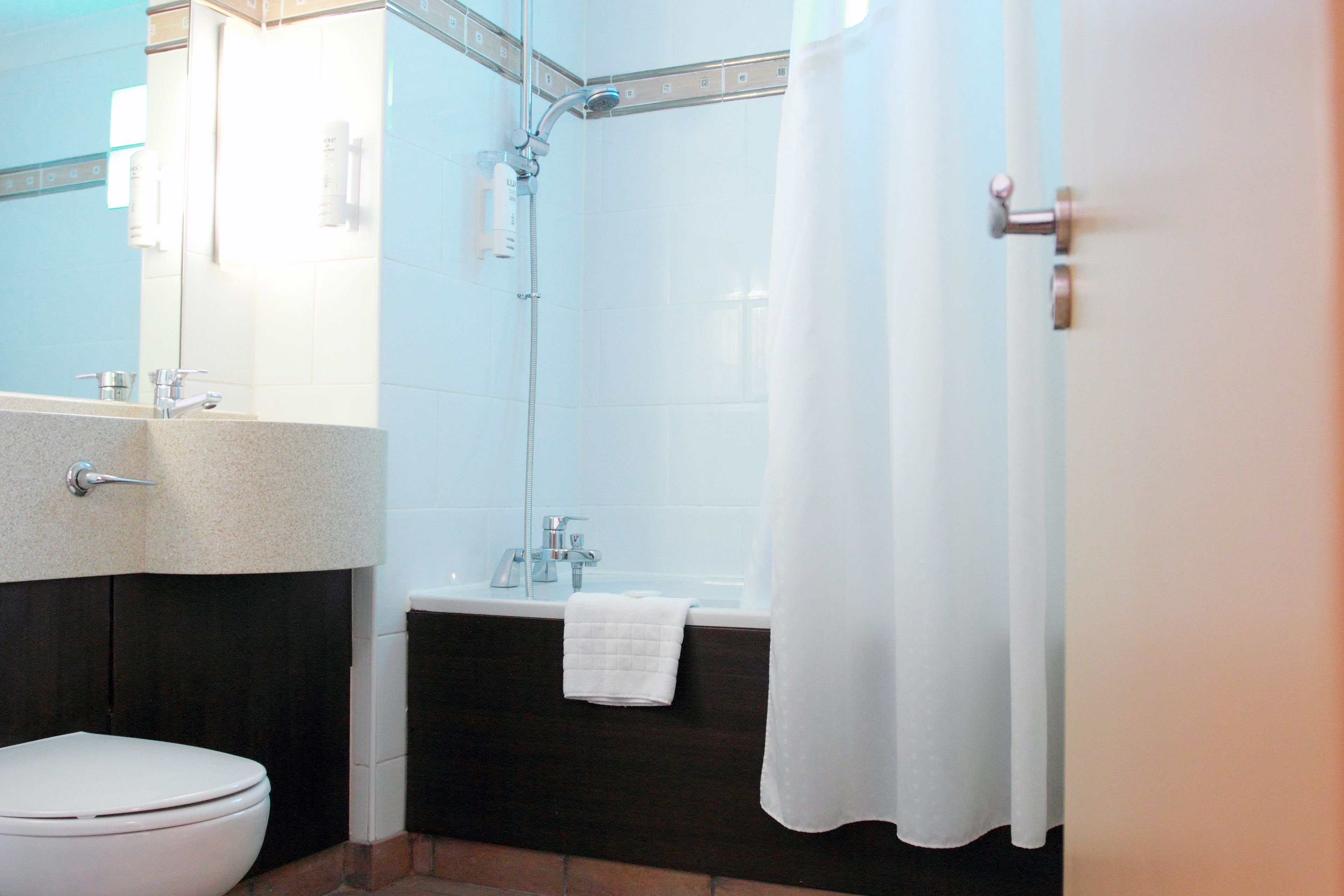 Un baño con inodoro blanco, lavamanos, bañera y ducha.
