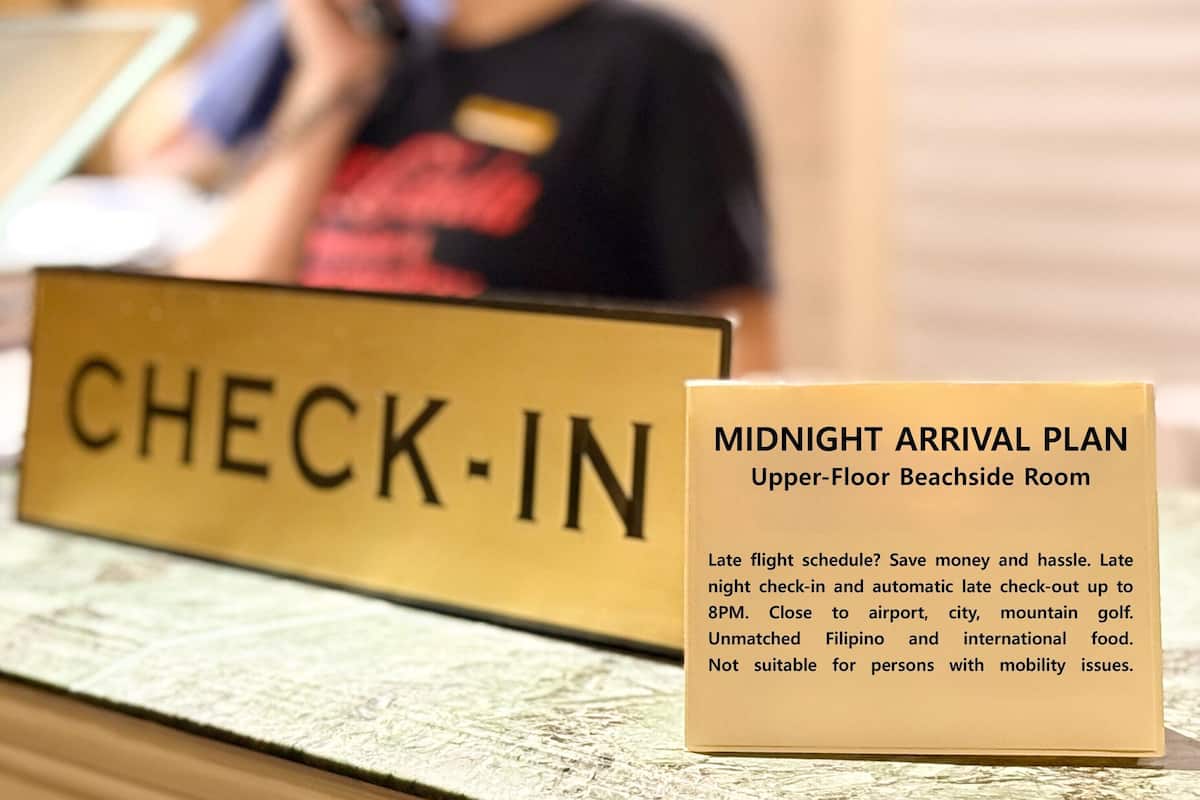 Schild für den Check-In-Bereich und einen Plan für Ankünfte nach Mitternacht, speziell für das Strandzimmer im Obergeschoss. Details zu späten Check-ins und automatischer späten Ausreise.