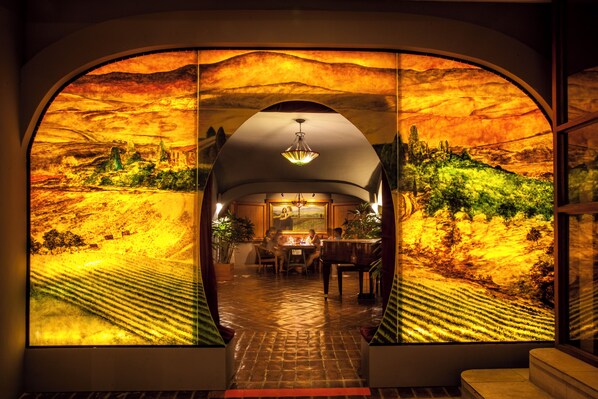 An arched doorway with a view of a dining area and a piano. -  Plantation Bay a Real Resort with a Real Spa (Lapu-Lapu)