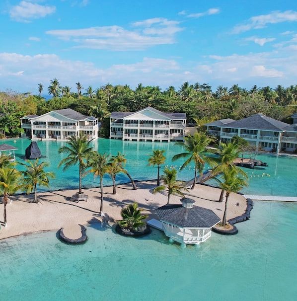 A resort with multiple buildings, a large pool, and palm trees. - Plantation Bay a Real Resort with a Real Spa (Lapu-Lapu)
