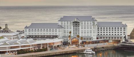 Un hotel frente al agua con varias edificaciones, un muelle y un bote.