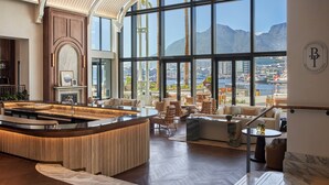 A spacious, well-lit interior with a large window offering a view of a city and mountains. - InterContinental Table Bay Cape Town by IHG (Cape Town)