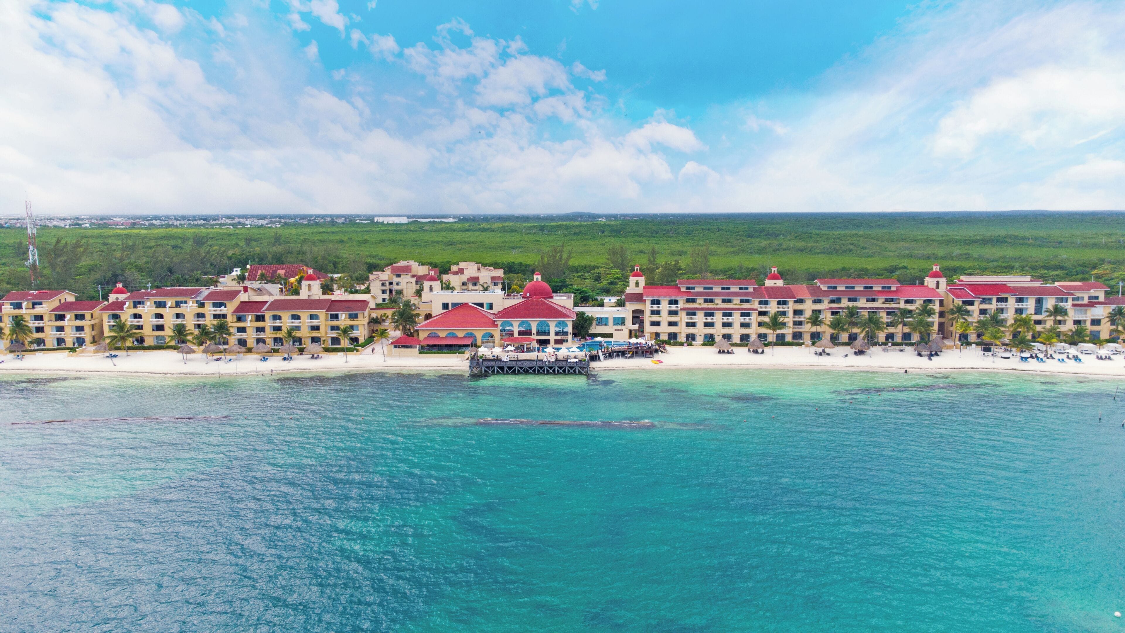 Un resort con varios edificios, un muelle y una playa.