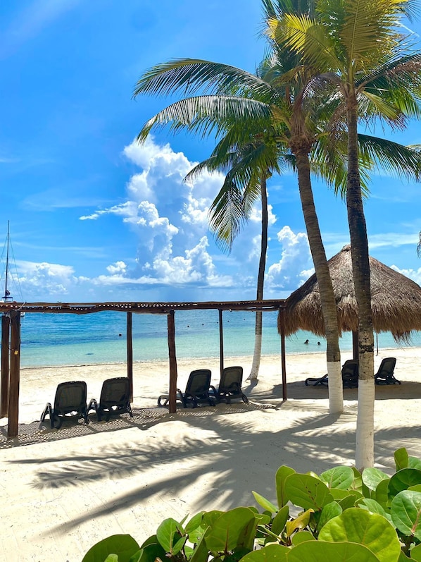 Privat strand, vit sandstrand, solstolar och parasoller