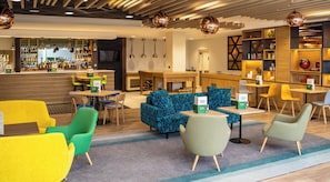 A hotel lobby with a bar, seating area, and a reception desk. - Holiday Inn Leicester - Wigston by IHG (Wigston)