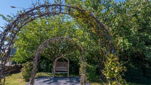 A wooden bench under a vine-covered archway in a garden. - Holiday Inn Leicester - Wigston by IHG (Wigston)