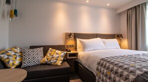 Ropa de cama hipoalergénica y caja de seguridad en la habitación 