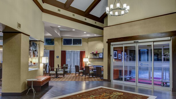 A spacious lobby with a large carpet, a seating area with tables and chairs, and a glass door entrance. - Hampton Inn & Suites N. Ft. Worth-Alliance Airport (Fort Worth)