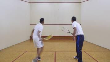 Una cancha de squash con dos jugadores.