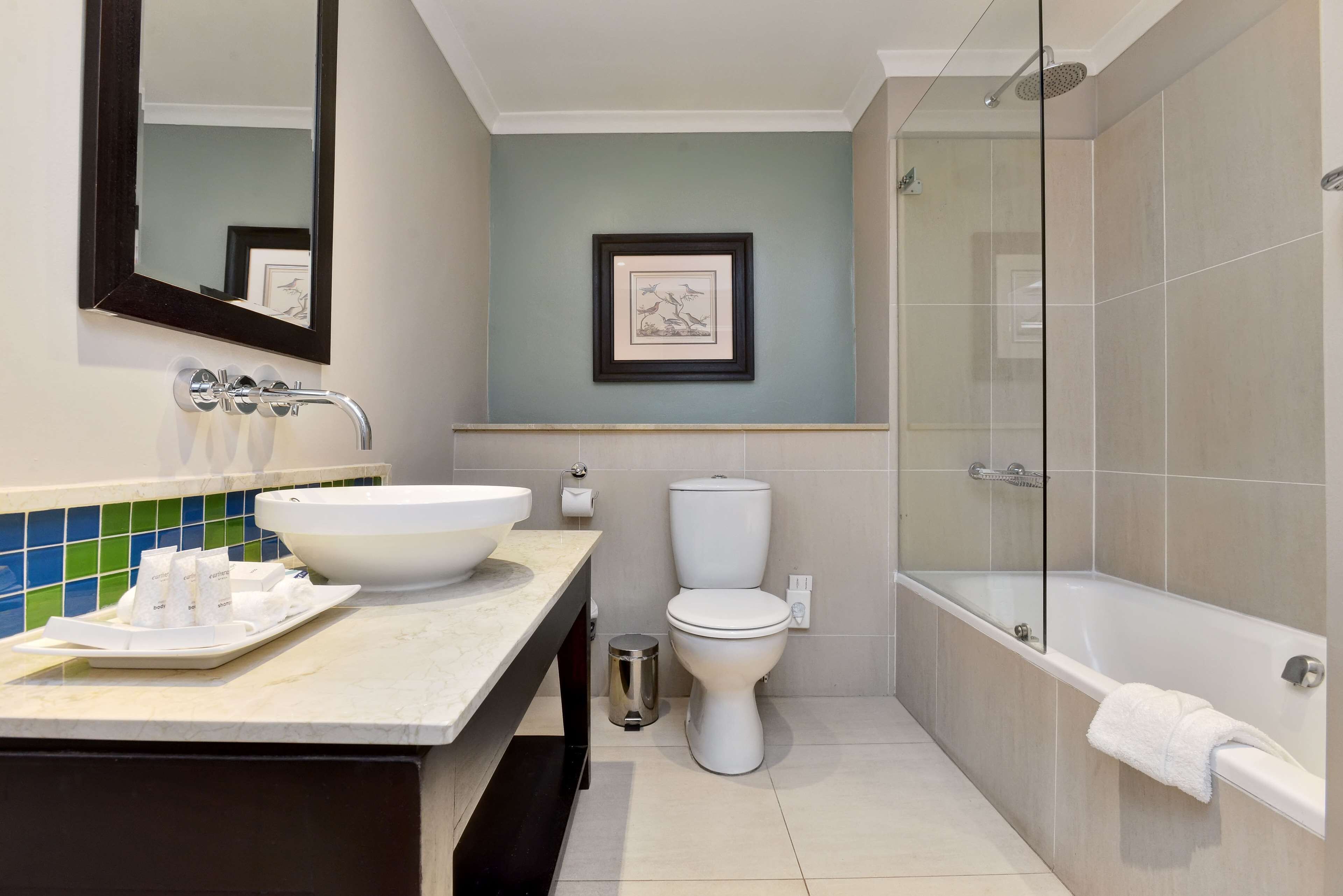 A modern bathroom with a sink, toilet, and bathtub.