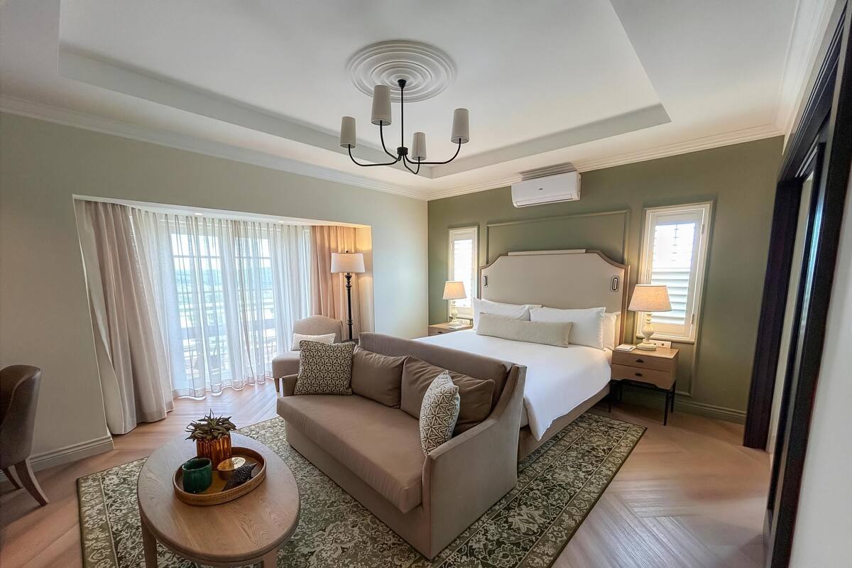 Ein Hotelzimmer mit Bett, einer Couch, einem kleinen Tisch und einer Deckenleuchte.