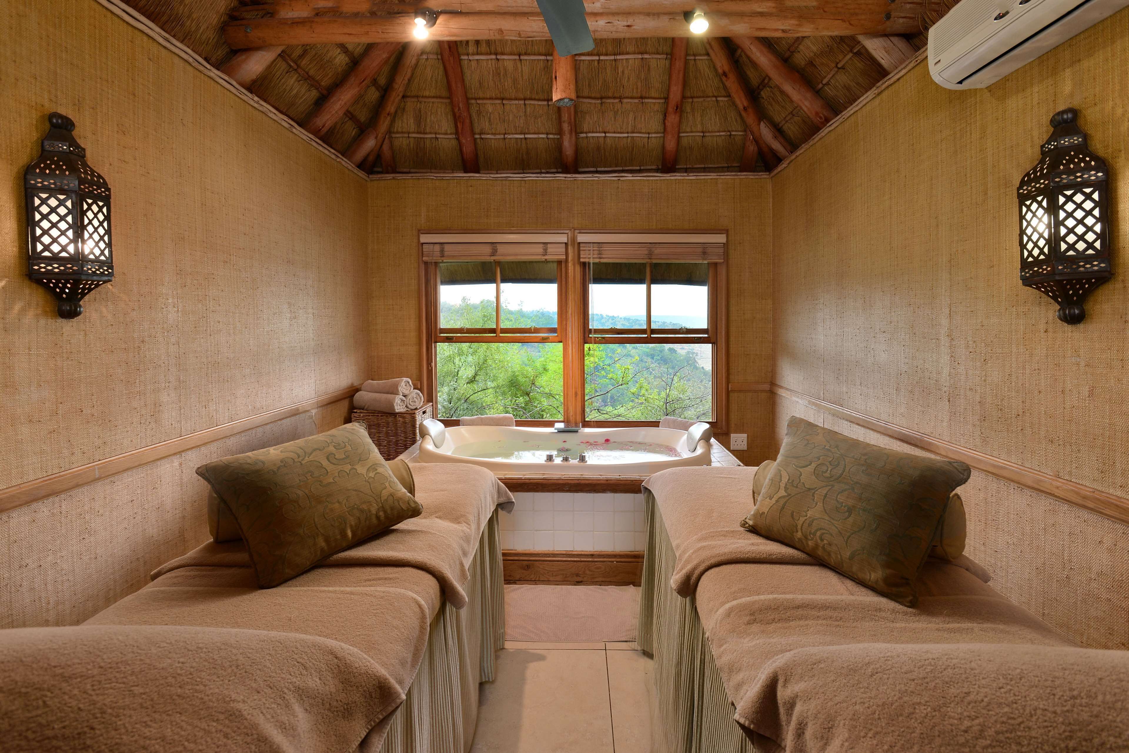 A room with two beds, a large window, and a bathtub.