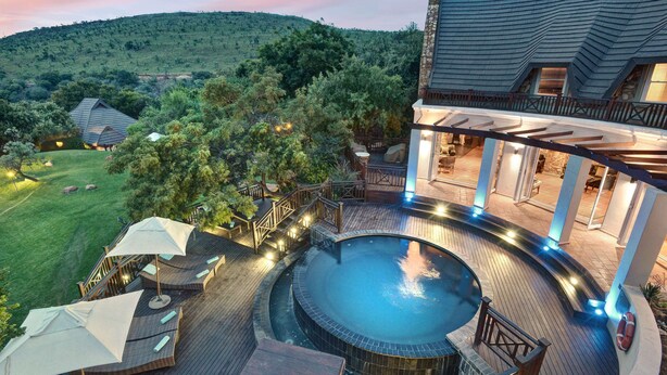 A pool area with a hot tub, wooden deck, and outdoor seating. - Mount Grace Hotel & Spa (Magaliesberg)