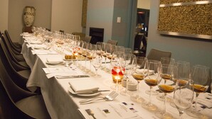 A long dining table set with multiple wine glasses, plates, and cutlery, indicating a formal dining arrangement. - Ten Bompas (Randburg)