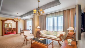 A spacious living room with a sofa, armchairs, a coffee table, and a chandelier. - Aryaduta Lippo Village (Curug)