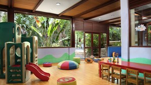 A children's play area with a slide, colorful bean bags, and a table with chairs. - Aryaduta Lippo Village (Curug)