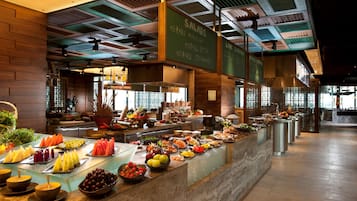 A buffet area with a variety of fruits and vegetables displayed on a marble counter.