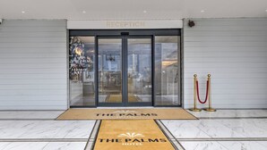 The reception area of The Palms Hotel with a marble floor and a red carpet leading to the entrance. - Palms Hotel & Retreat By Palette London Romford (Hornchurch)