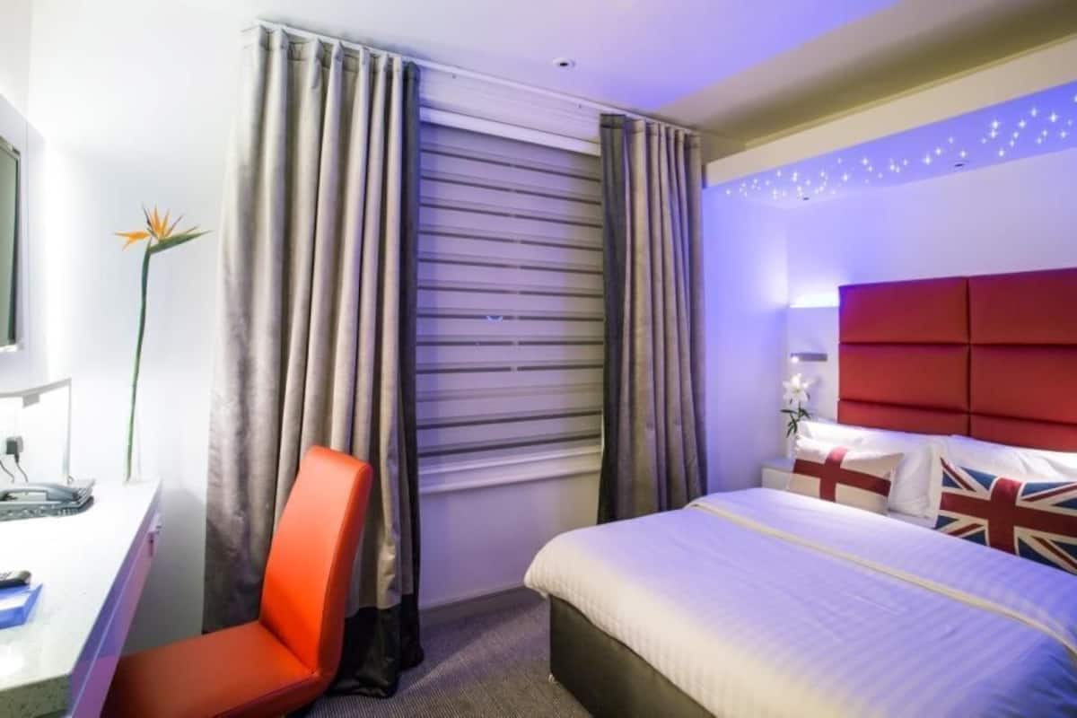 A hotel room with a bed, a desk, and a chair.