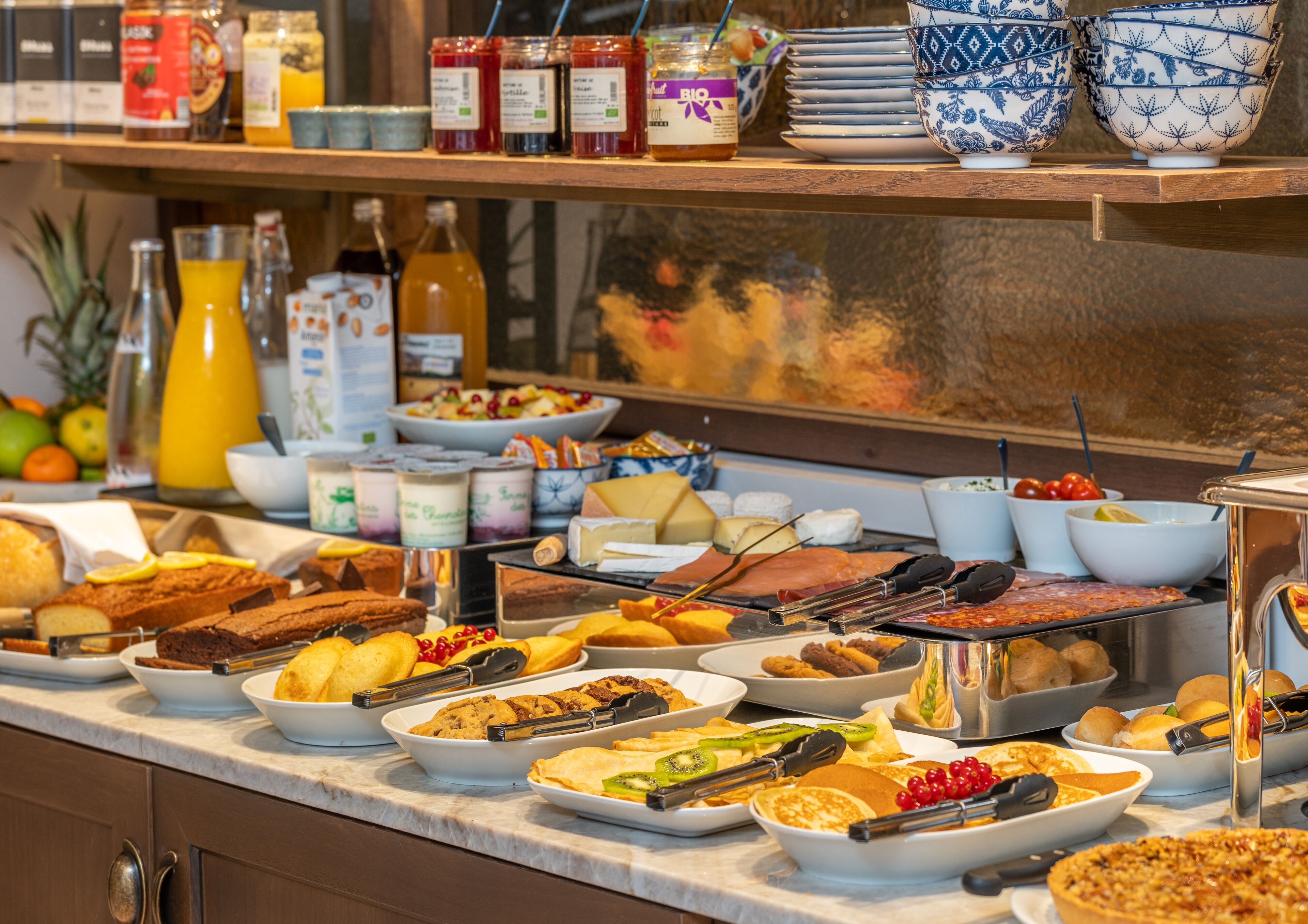 A buffet with various food items including cakes, pastries, and fruits.