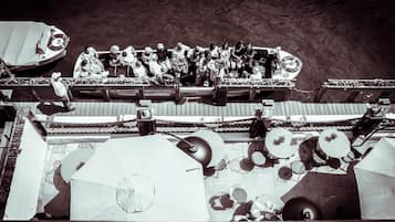 A boat with people on deck, surrounded by umbrellas and a netted railing.