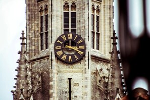 Stunning clock tower with an ornate clock face atop a historic facade featuring intricate architectural details.