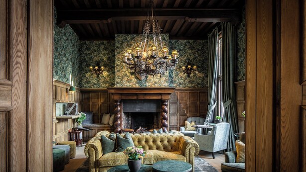 A traditional living room with a fireplace, a large sofa, and a chandelier. - Hotel de Orangerie by CW Hotel Collection - Small Luxury Hotels of the World (Bruges)