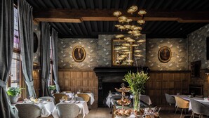 A dining area with tables set for a meal, wooden beams on the ceiling, and framed artwork on the walls. - Hotel de Orangerie by CW Hotel Collection - Small Luxury Hotels of the World (Bruges)