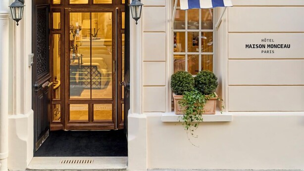 A hotel entrance with a double door, a small balcony with potted plants, and a sign reading "Hôtel Maison Monceau Paris". - Hôtel Maison Monceau (Paris)