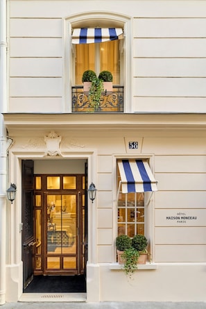 A hotel entrance with a double door, a small balcony with potted plants, and a sign reading "Hôtel Maison Monceau Paris". - Hôtel Maison Monceau (Paris)