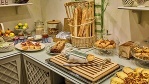 A buffet table with various breads, pastries, and condiments. - Hôtel Maison Monceau (Paris)